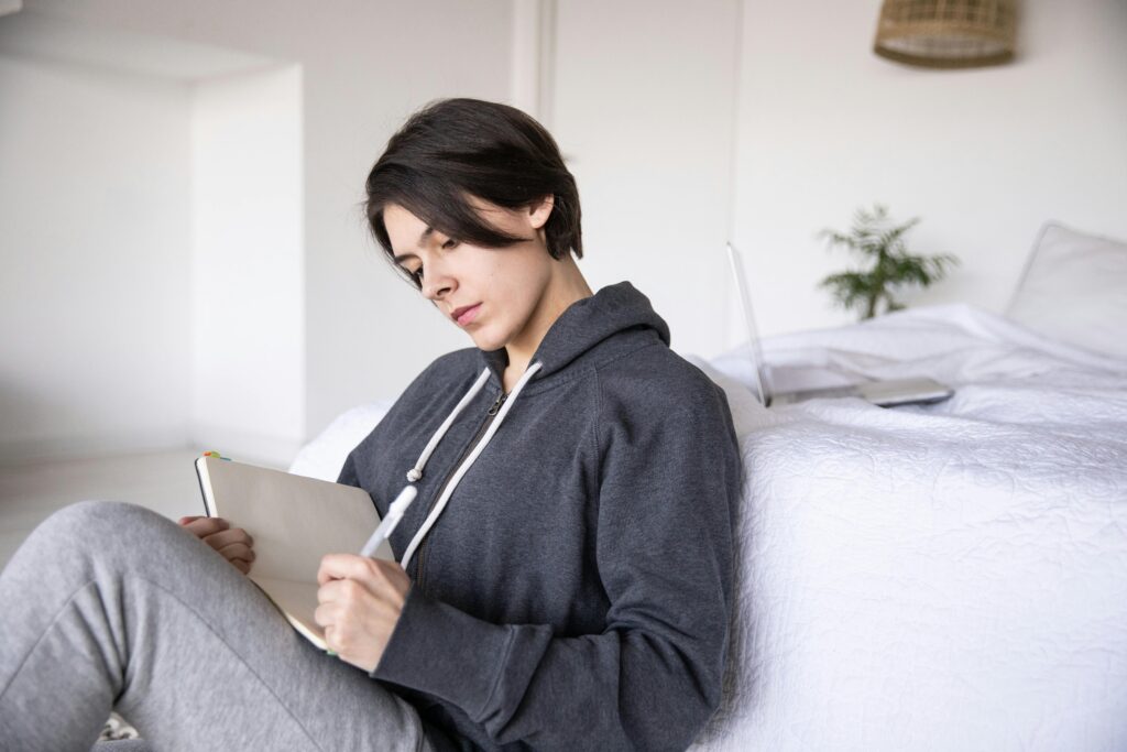 woman journaling in bedroom